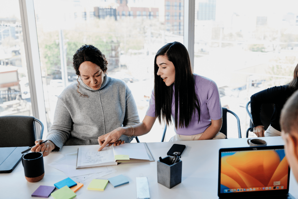 Two colleagues go over their project in a conference room.