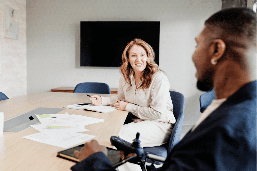 Two colleagues chat in a conference room